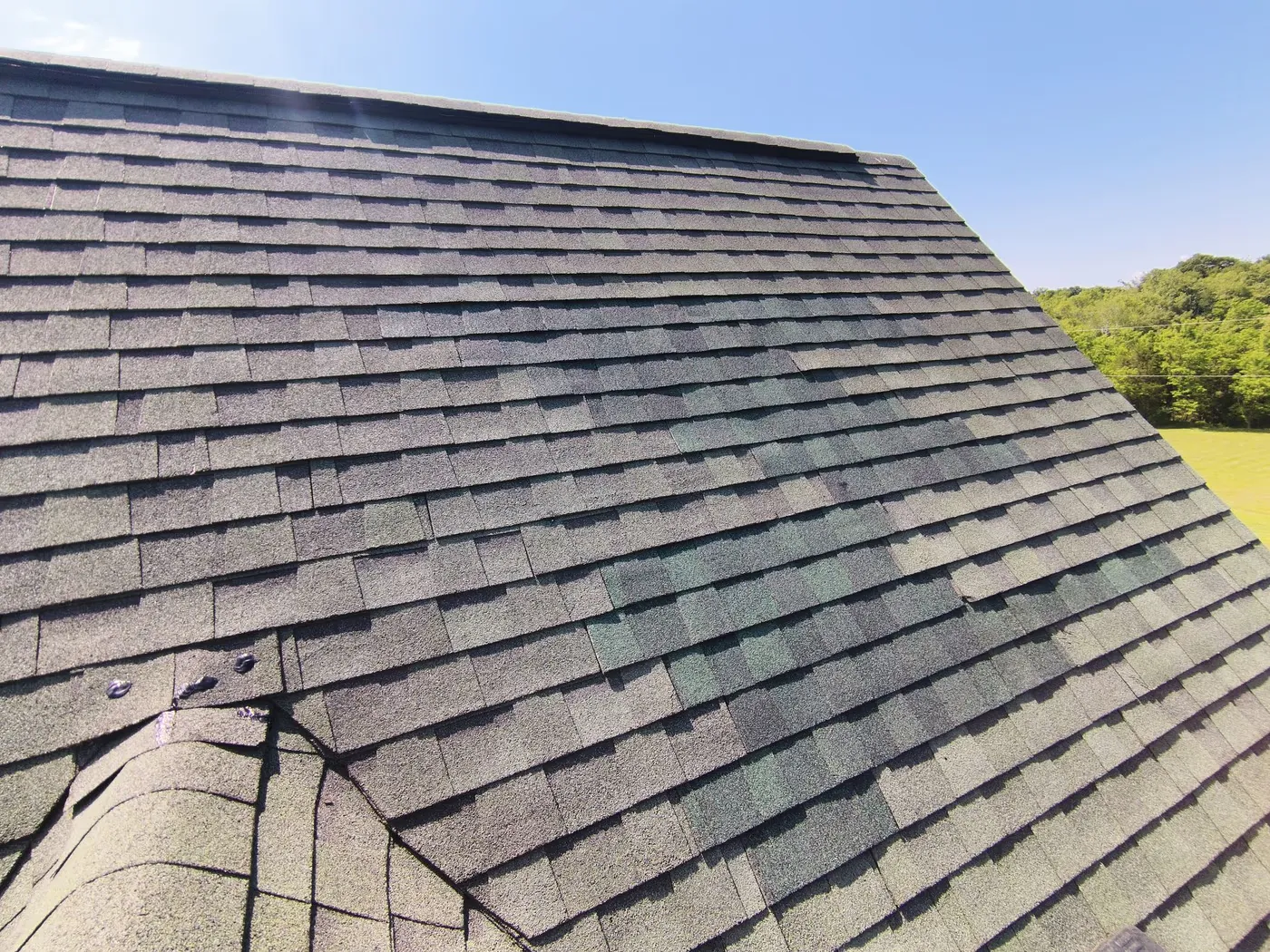 Damaged shingle roof repair area on a Virginia home