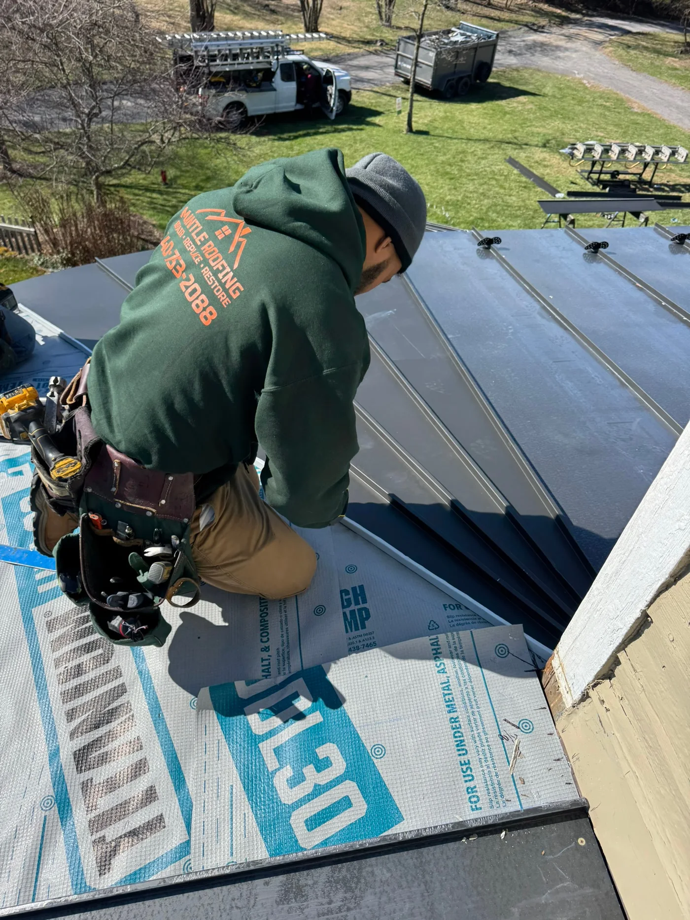 A Mantle Roofing installer working on standing-seam metal roof panels