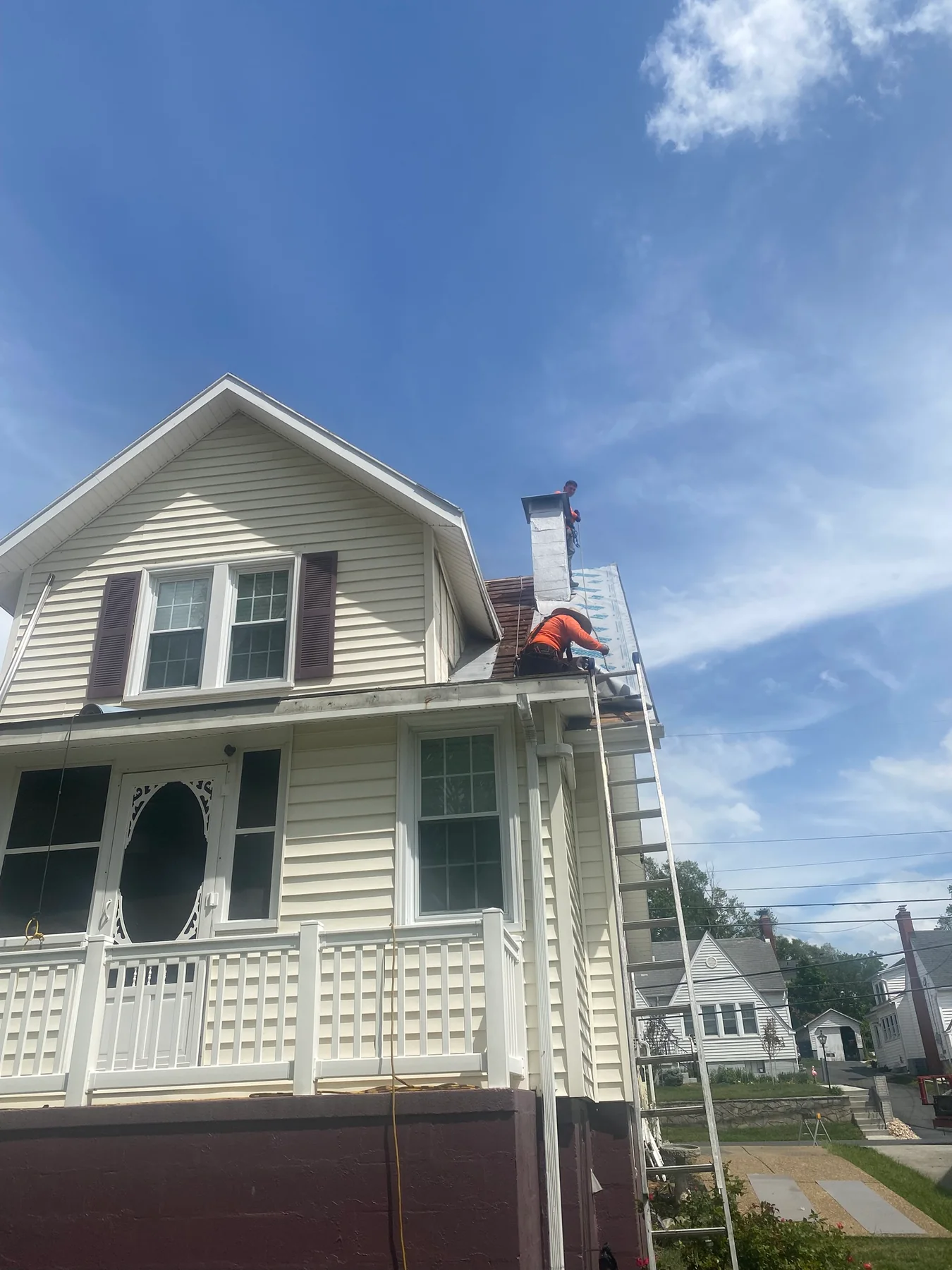 Roofing crew installing standing seam metal panels on a Harrisonburg home